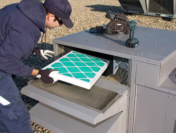 Technician changing the filter on a commercial HVAC filter